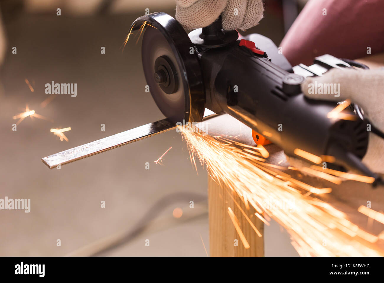 Worker Using Angle Grinder in Factory and throwing sparks Stock Photo