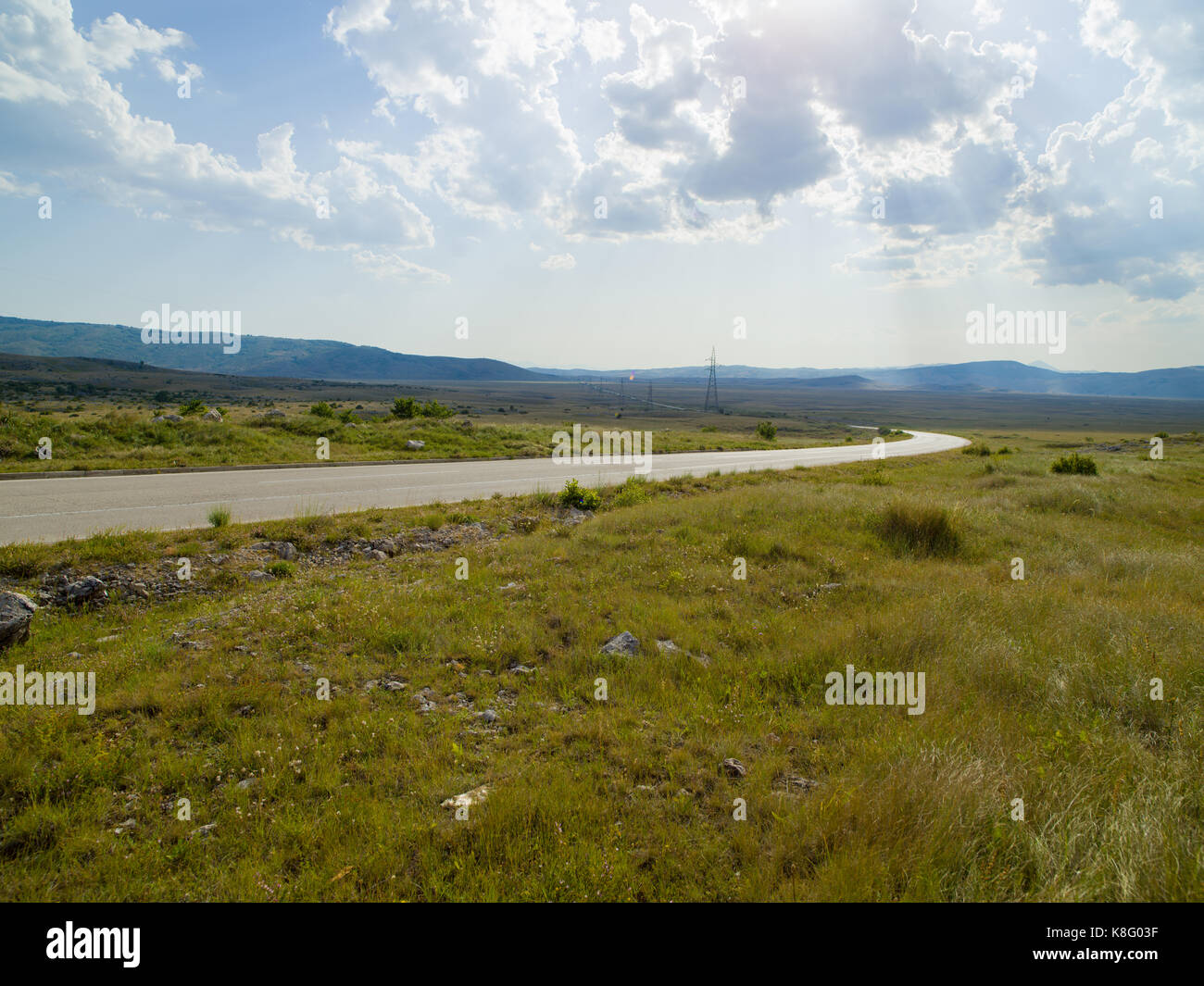 Evening summer landscape with green grass, road and clouds Stock Photo ...