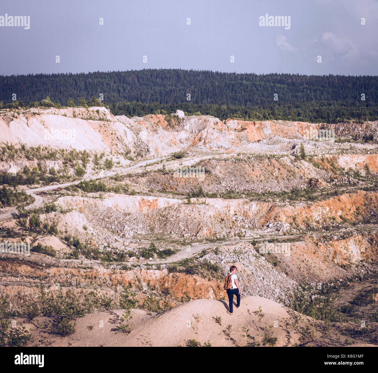 Young male hiker looking over his shoulder from quarry Stock Photo