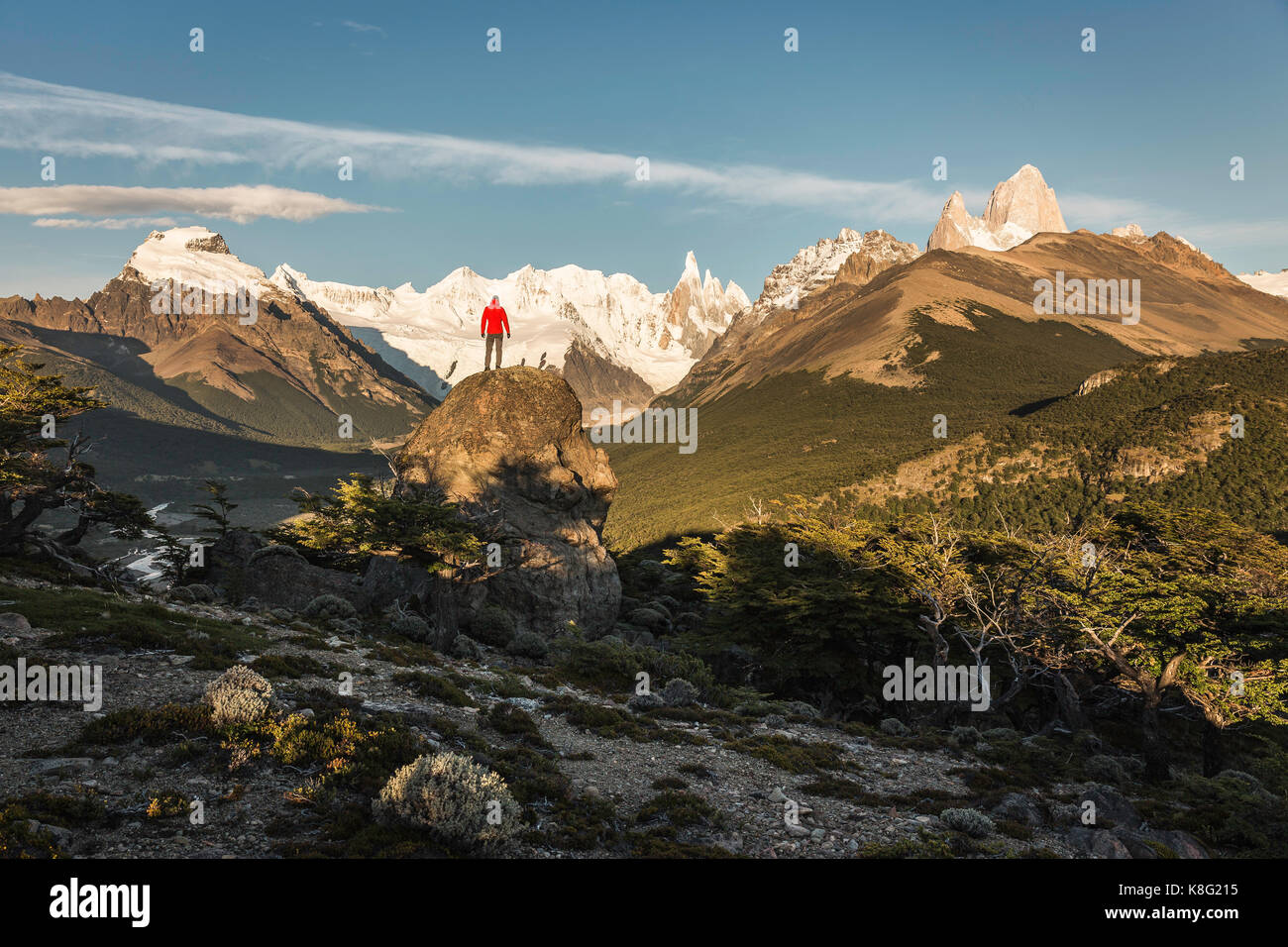 Male hiker looking out Cerro Torre and Fitz Roy mountain range in Los Glaciares National Park, Patagonia, Argentina Stock Photo