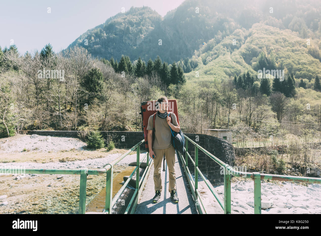 Young male boulderer on river footbridge, Lombardy, Italy Stock Photo ...