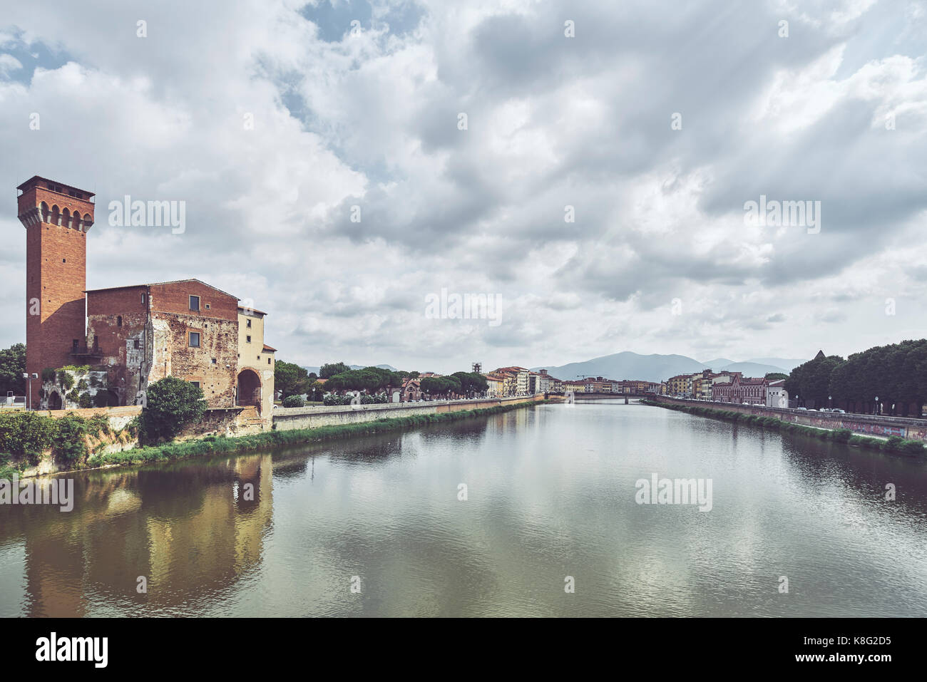 Old industrial tower on waterfront of Arno river, Pisa, Tuscany, Italy Stock Photo