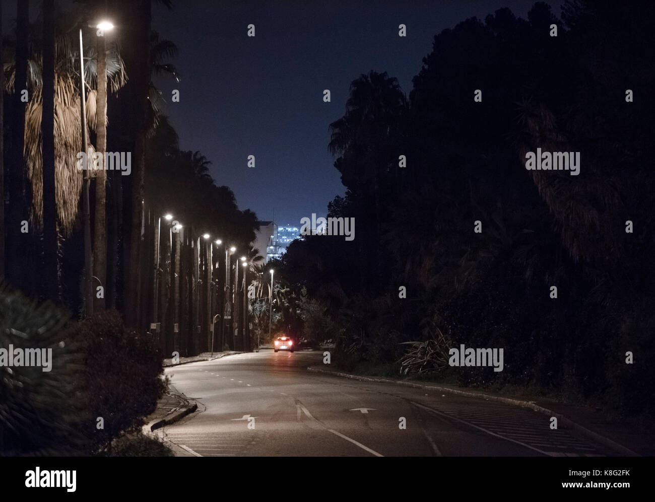 Car break lights and street lamps on city road at night, Barcelona, Spain Stock Photo