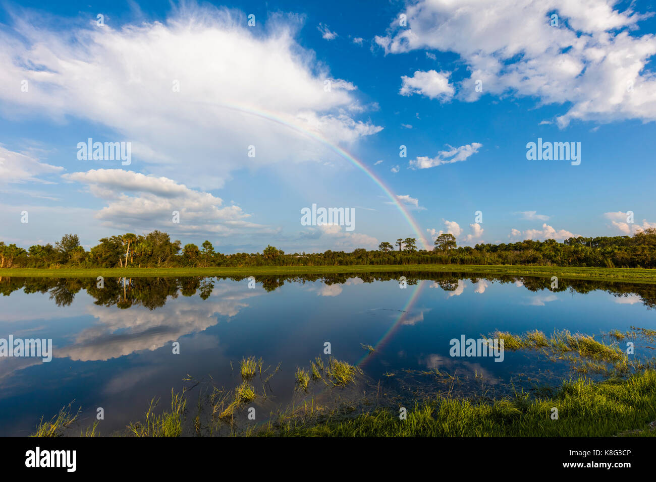 Rainbow in blue sky with white clouds hi-res stock photography and ...