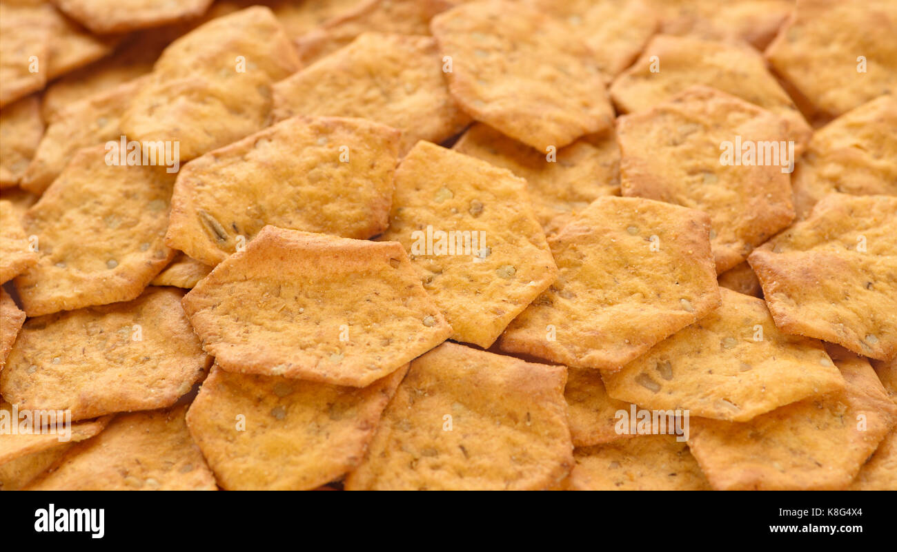 Organic crispy whole grain, multigrain baked crackers as a background. Whole Grain Blend: Oats, Brown Rice Flour, Millet, Quinoa, Amaranth, Sesame See Stock Photo