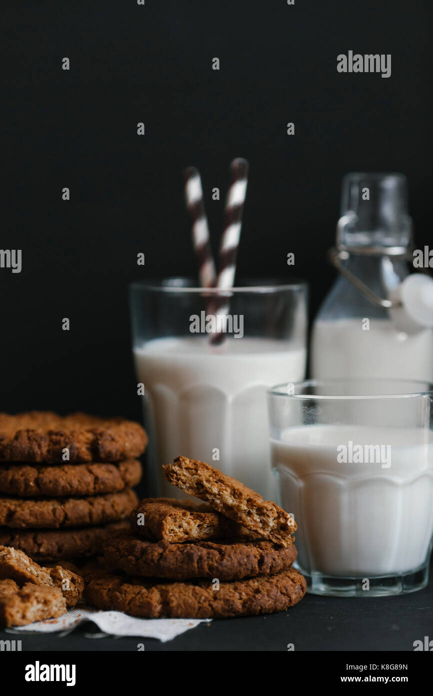Cookies and milk on table against black background Stock Photo Alamy