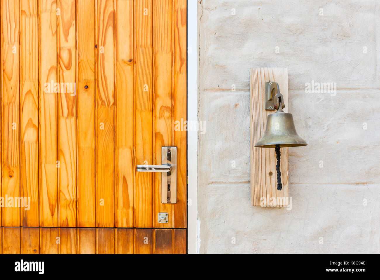 Brass bell attached outside next to house door for noise ringing