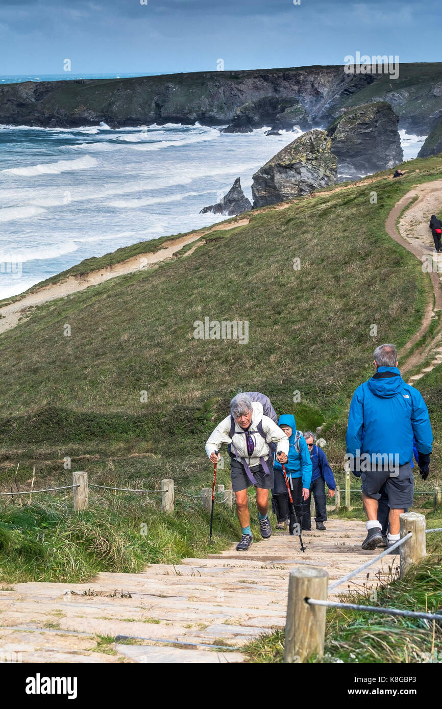 Bedruthan Steps - Walkers climbing up steep steps on the South West Coast Path at Bedruthan Steps on the North Cornwall coast. Stock Photo