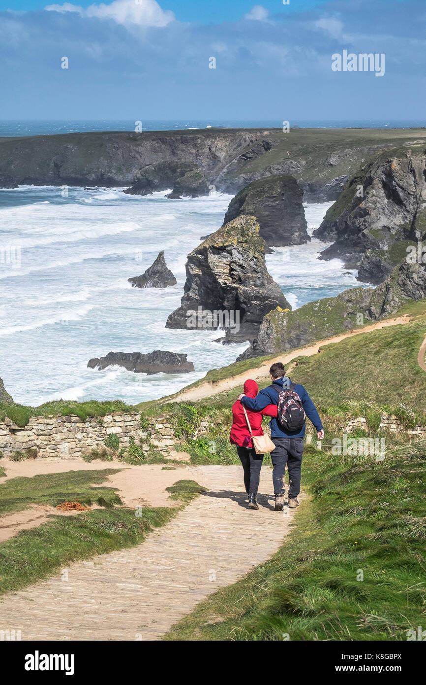 Bedruthan Steps - a couple walking and hugging each other on the South West Coast Path at Bedruthan Steps on the North Cornwall coast. Stock Photo