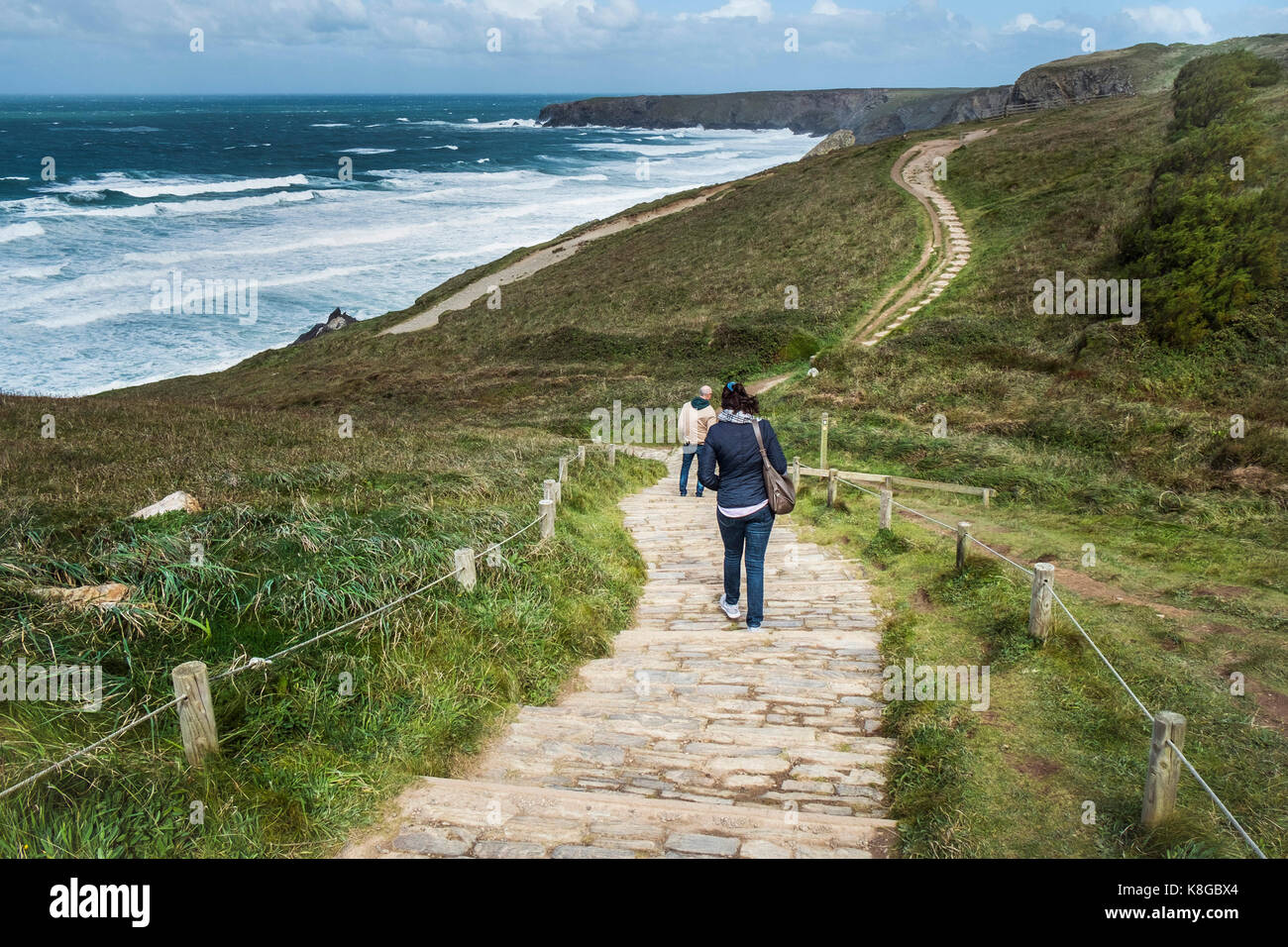 Bedruthan Steps - people walking down the costal footpath at Bedruthan Steps on the North Cornwall coast. Stock Photo