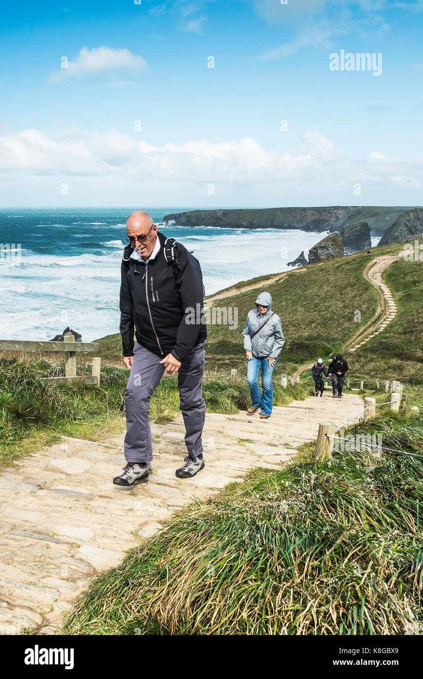 Bedruthan Steps - walkers climbing up the steep footpath at Bedruthan Steps on the North Cornwall coast. Stock Photo