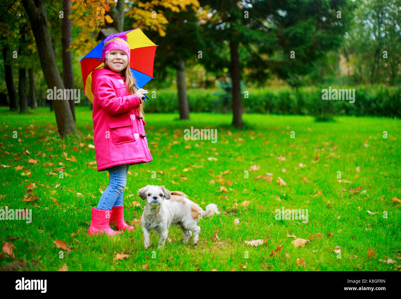 happy girl with her dog and a colorful umbrella in he autumn park Stock ...