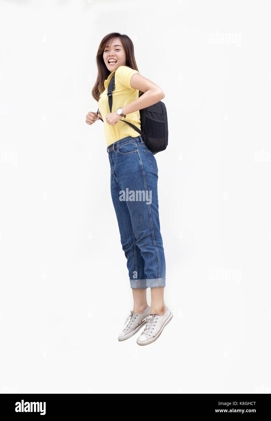 portrait happy teenage asian girl jump action with backpack and casual wearing to university or classroom concept on white isolate background Stock Photo