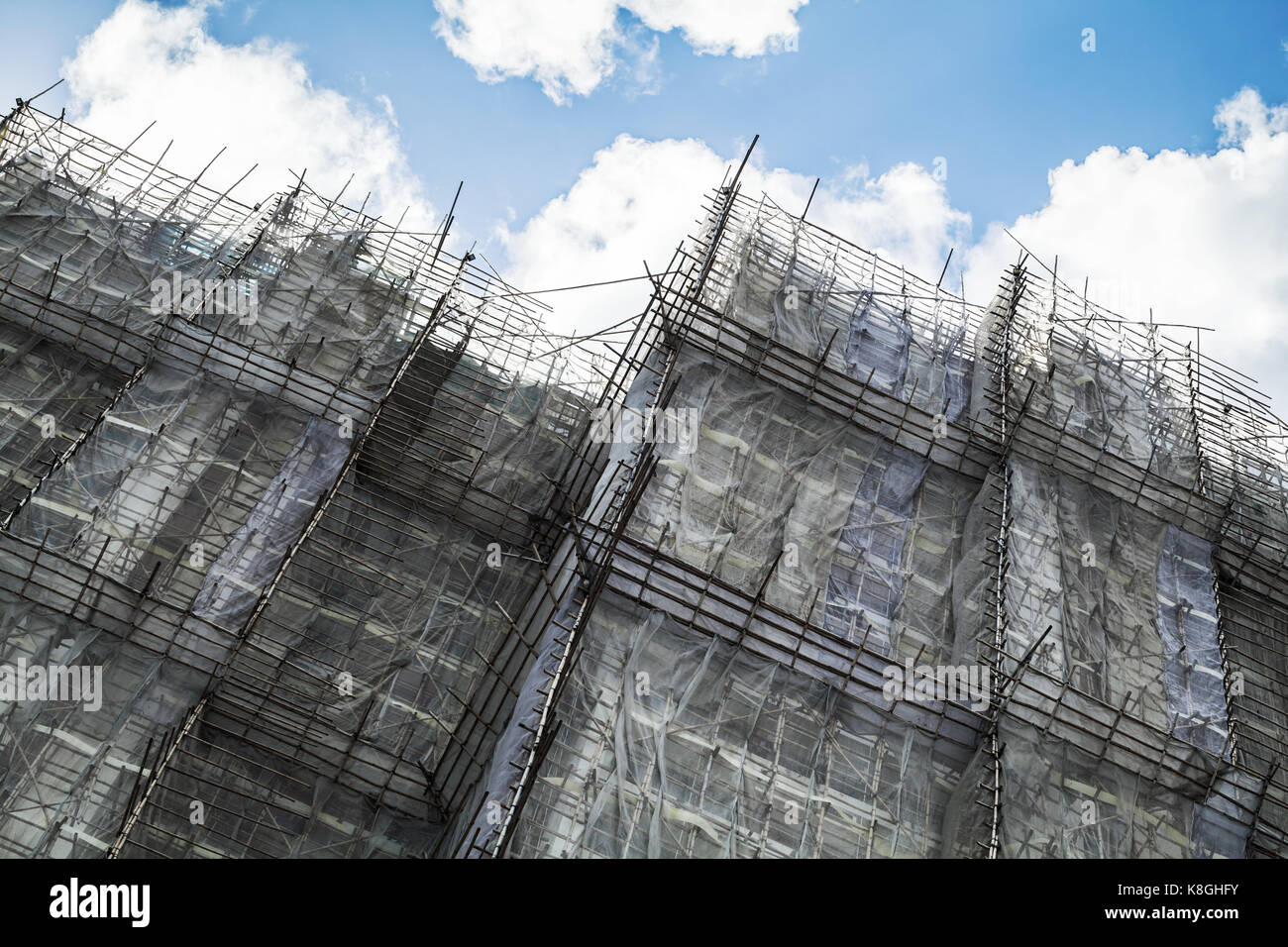 Modern block of flats is under construction, facade fragment with bamboo scaffolding structures, Hong Kong Stock Photo