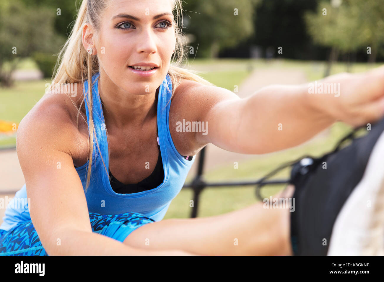 Young woman training in park, touching toes Stock Photo