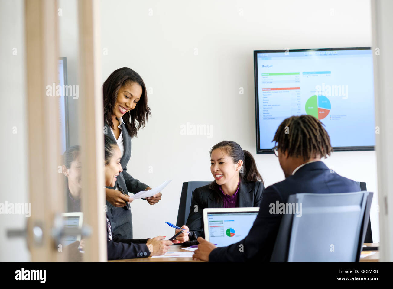 Businessman and businesswomen, sitting in office, having discussion, looking at data Stock Photo