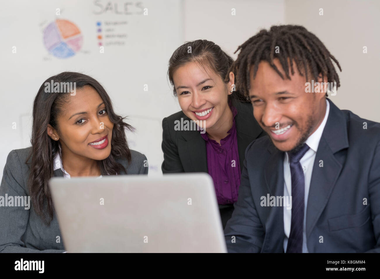 Businessman and businesswomen, in office, looking at laptop Stock Photo