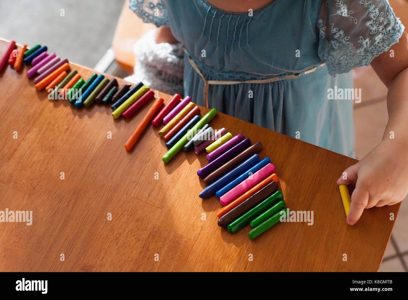 Girl lining up crayons in a row Stock Photo Alamy
