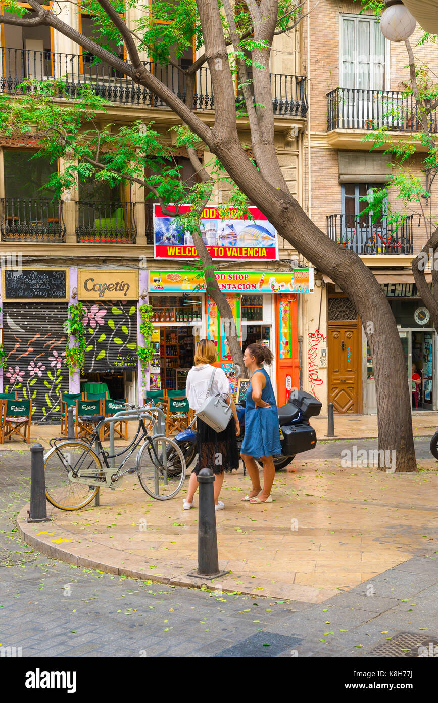 Women talking street, view of two women chatting on a street corner in the Plaza Tossal in the old town Barrio del Carmen area of Valencia, Spain. Stock Photo