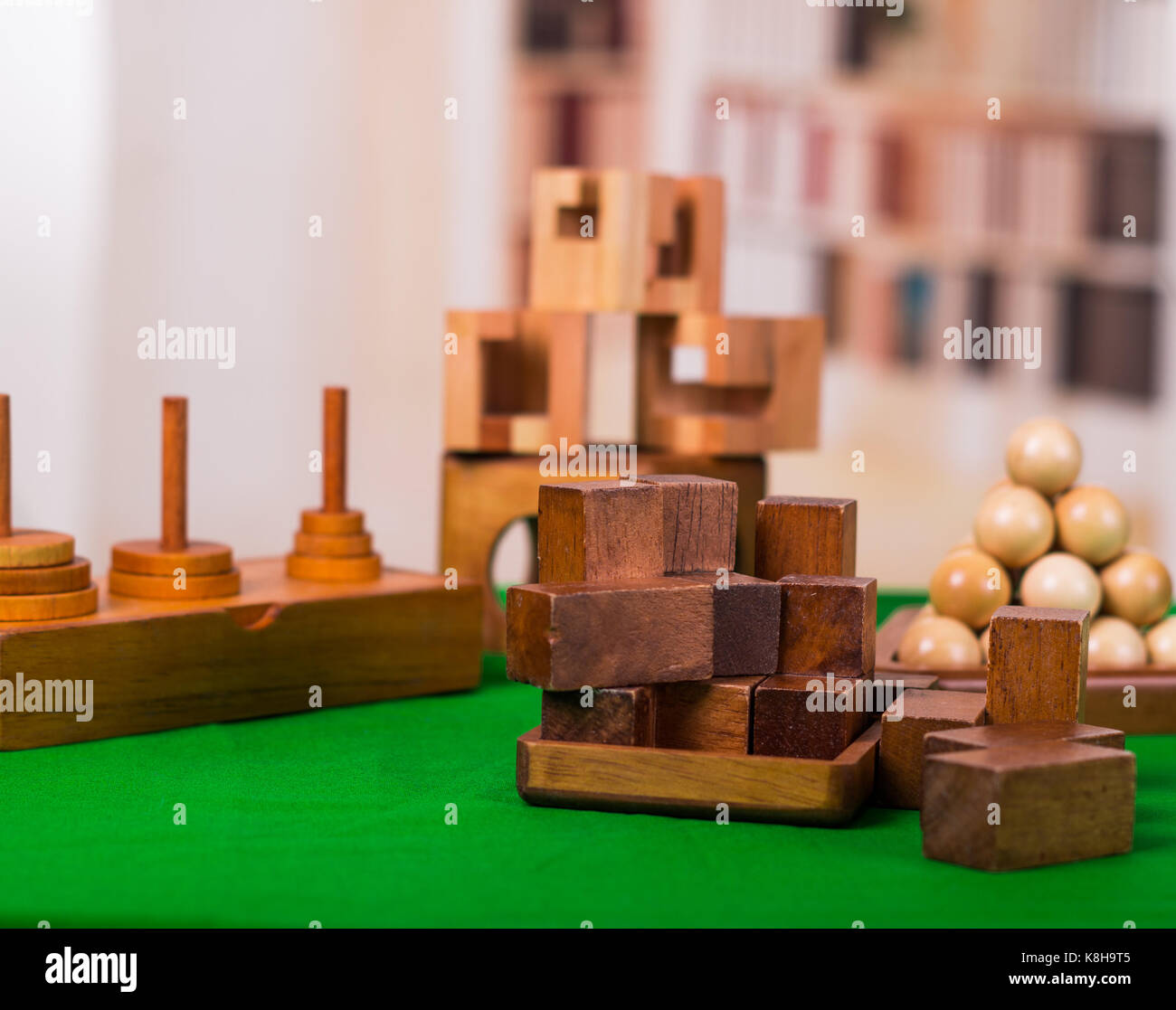 Wooden block brain teaser puzzle on green table in a blurred background
