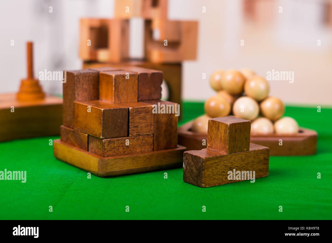 Wooden block brain teaser puzzle on green table in a blurred background