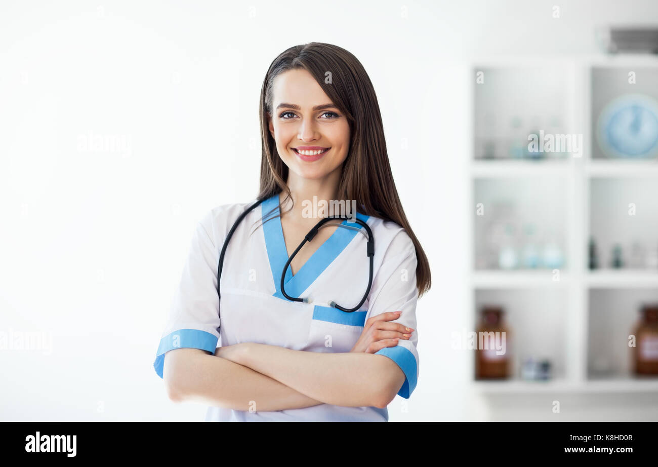 Portrait of confident smiling doctor with arms crossed in hospital ...