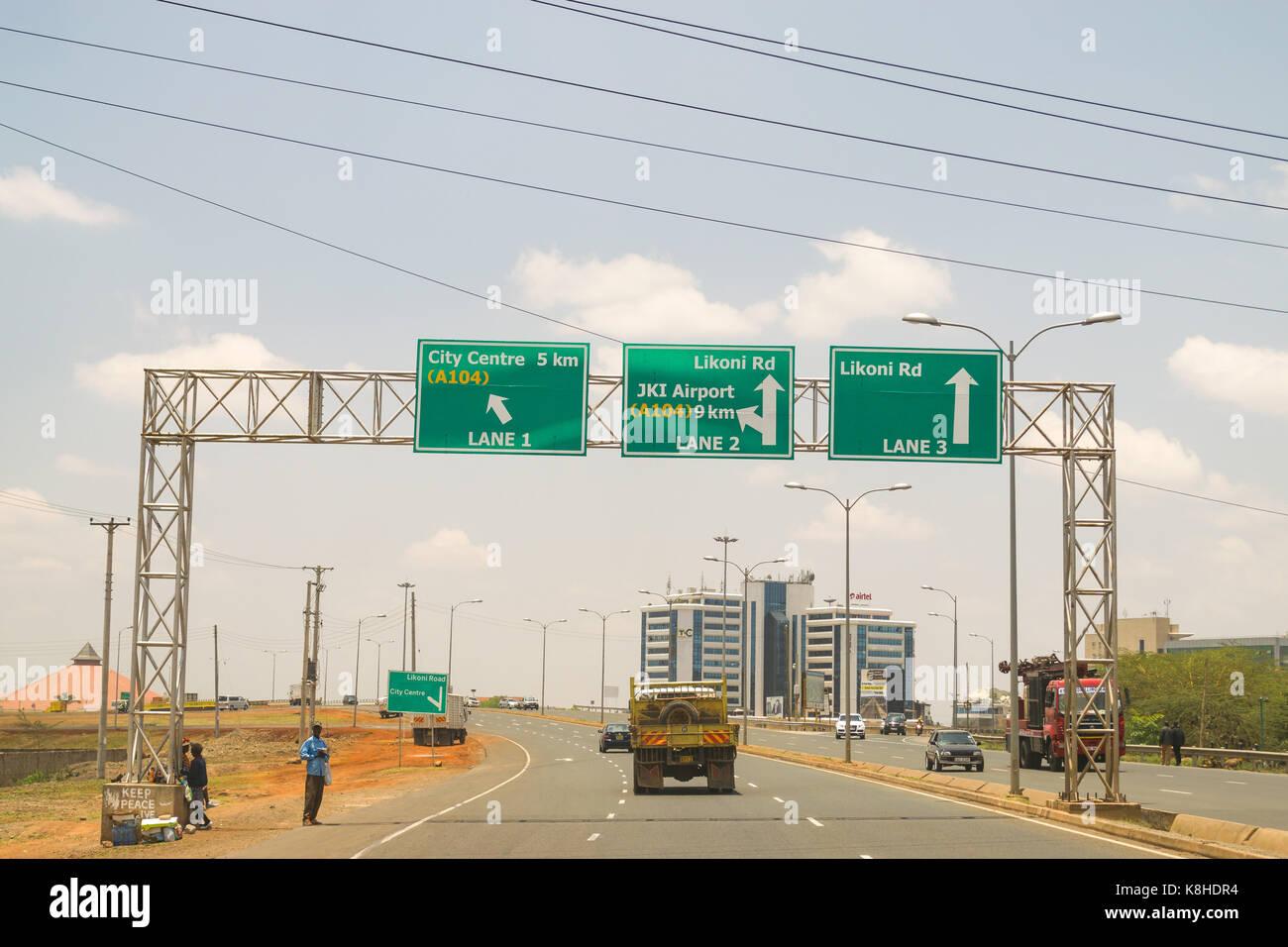 Southern bypass highway with vehicles driving in both directions and road signs with directions above, Kenya Stock Photo