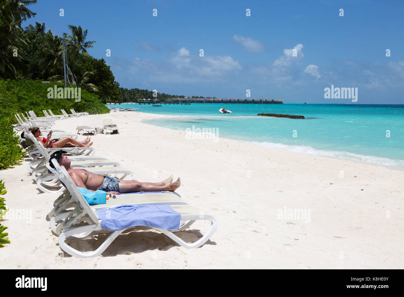 Maldives beach - tourists sunbathing on the beach, Kuramathi resort hotel, The Maldives, Asia Stock Photo