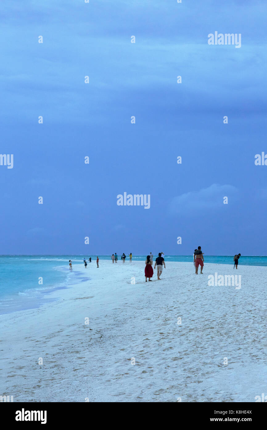 People gathering on the sandspit at dusk by the Indian Ocean , Kuramathi island resort, Kuramathi, the Maldives, Asia Stock Photo