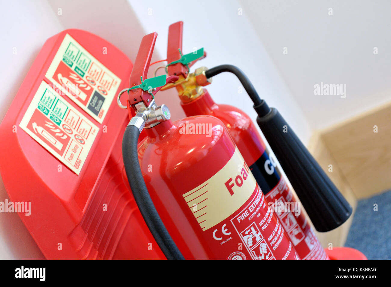two fire extinguishers on a specially designed holder on the wall in an