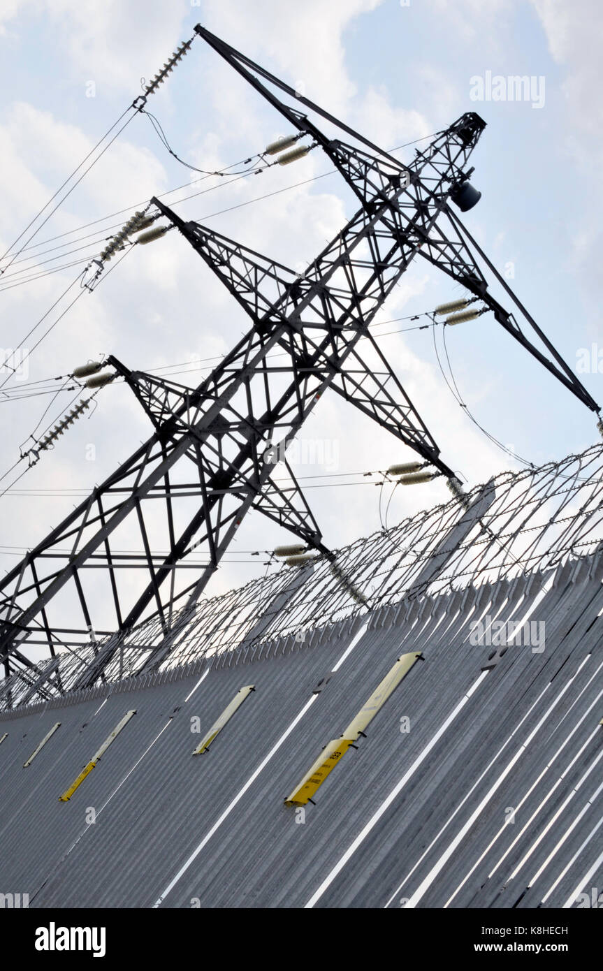 an electricity pylon next to a fence at a national grid substation