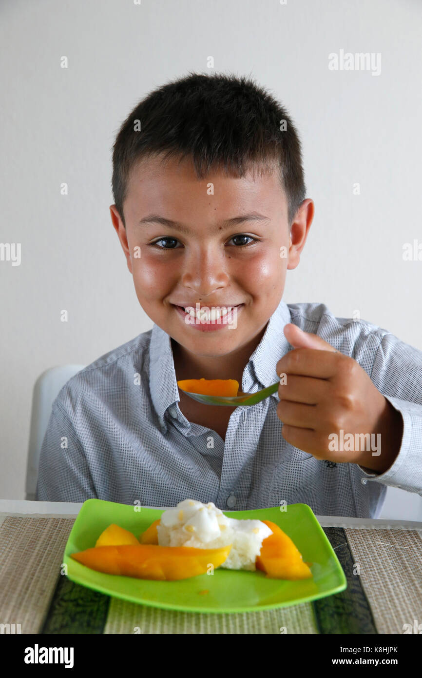 Boy eating sticky rice with mango. thailand. Stock Photo
