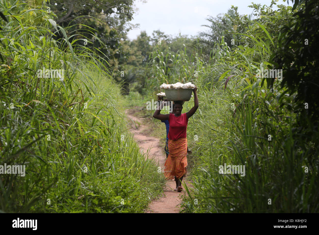 Women carrying platter with cassava on head. togo. Stock Photo