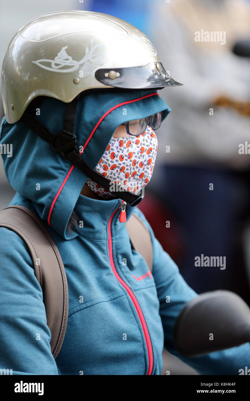 Woman riding a motorcycle on saigon street. vietnam. Stock Photo