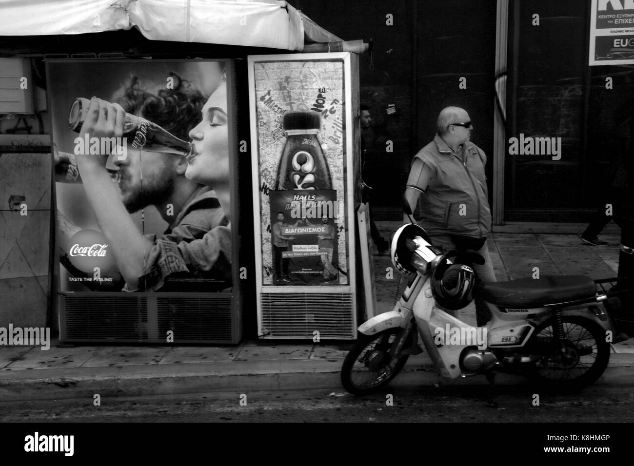 Athens Greece man standing by motorcycle next advertisments Stock Photo