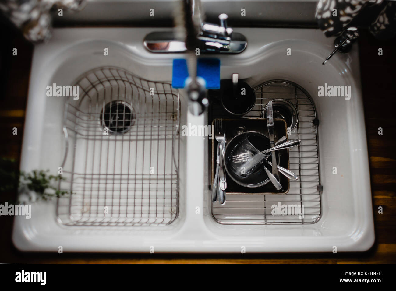 Overhead view of utensils on metal grate in kitchen sink at home Stock