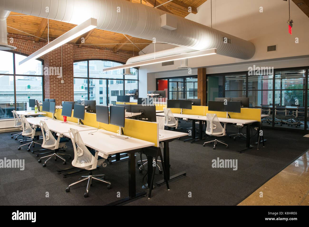 Trendy modern open concept loft office space with big windows, natural light and a layout to encourage collaboration, creativity and innovation Stock Photo
