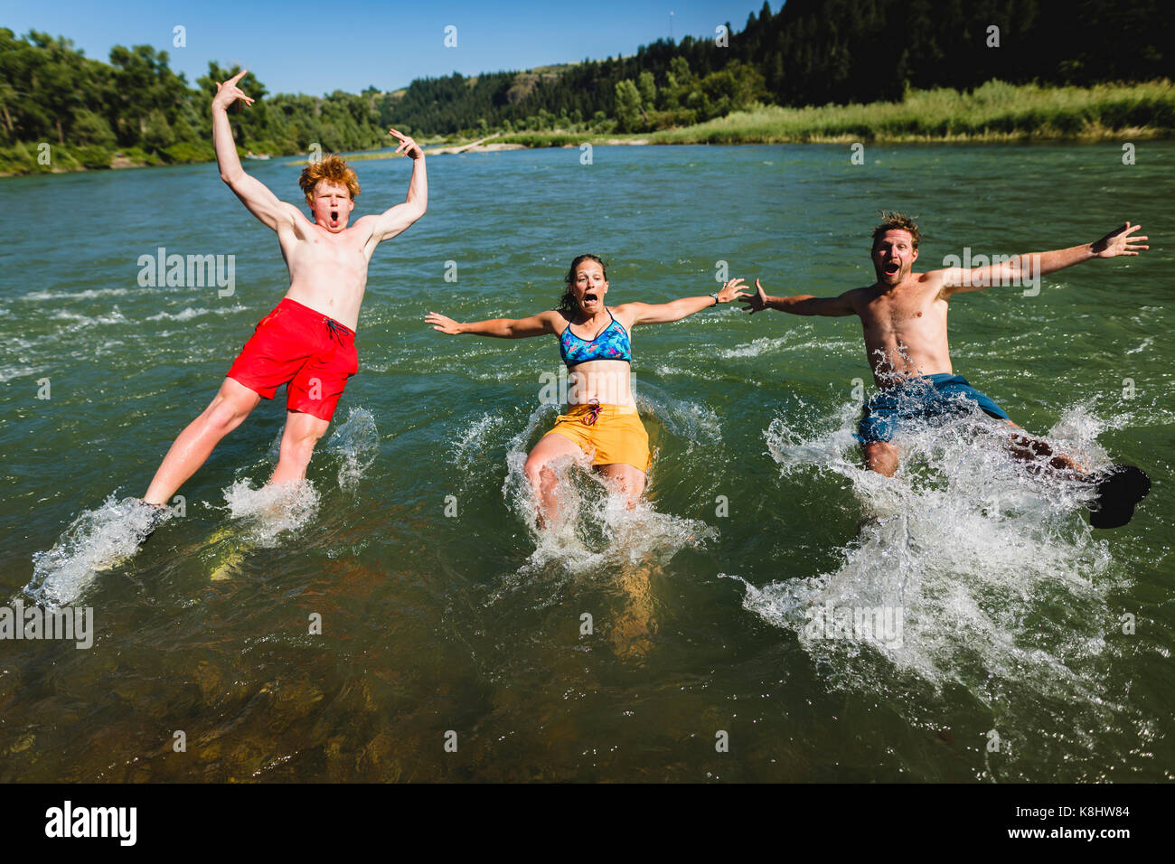 Friends jumping into lake Stock Photo - Alamy
