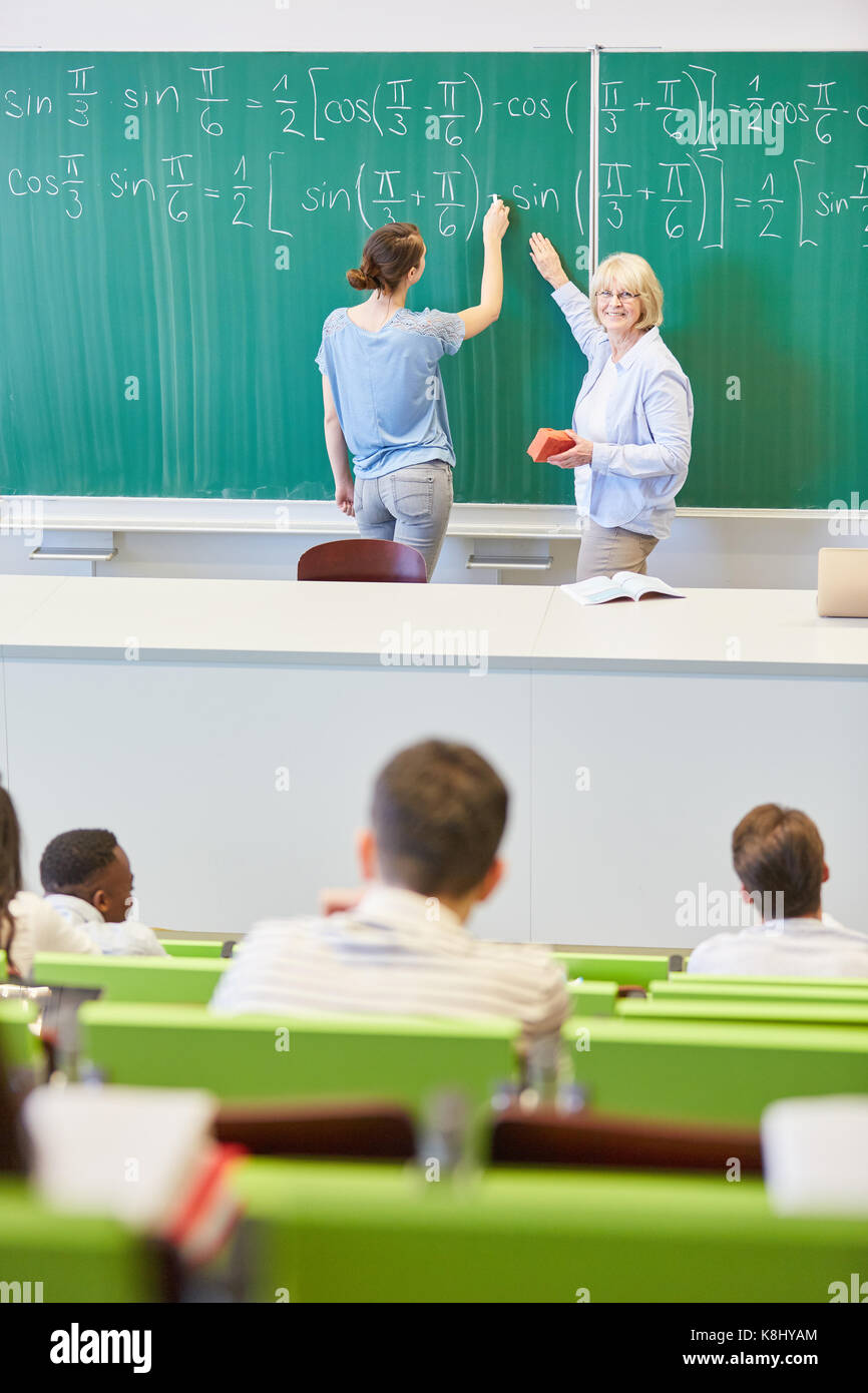 Teacher and student using chalkboard in maths Stock Photo