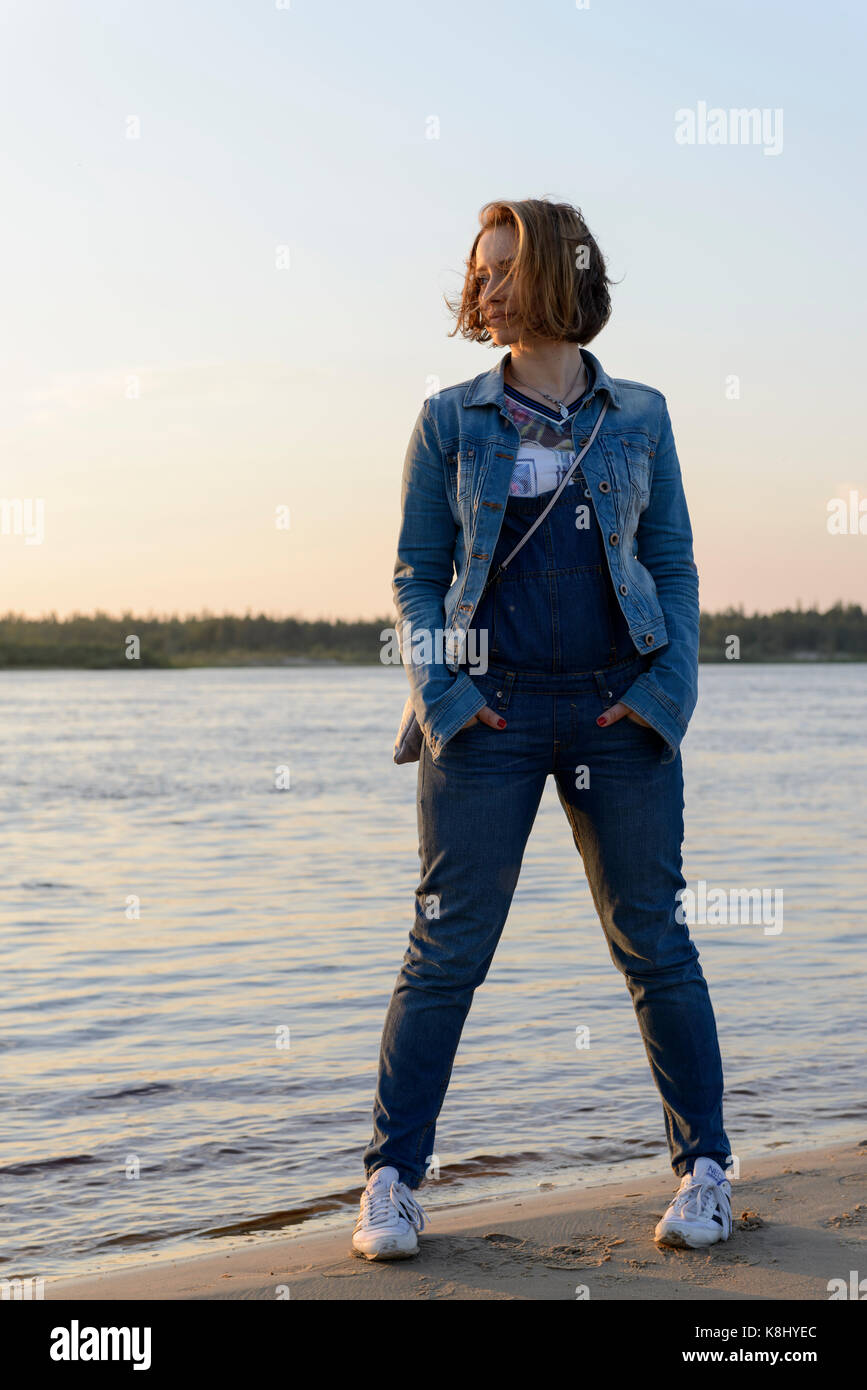 beautiful girl looks away on the river and sunset background Stock ...