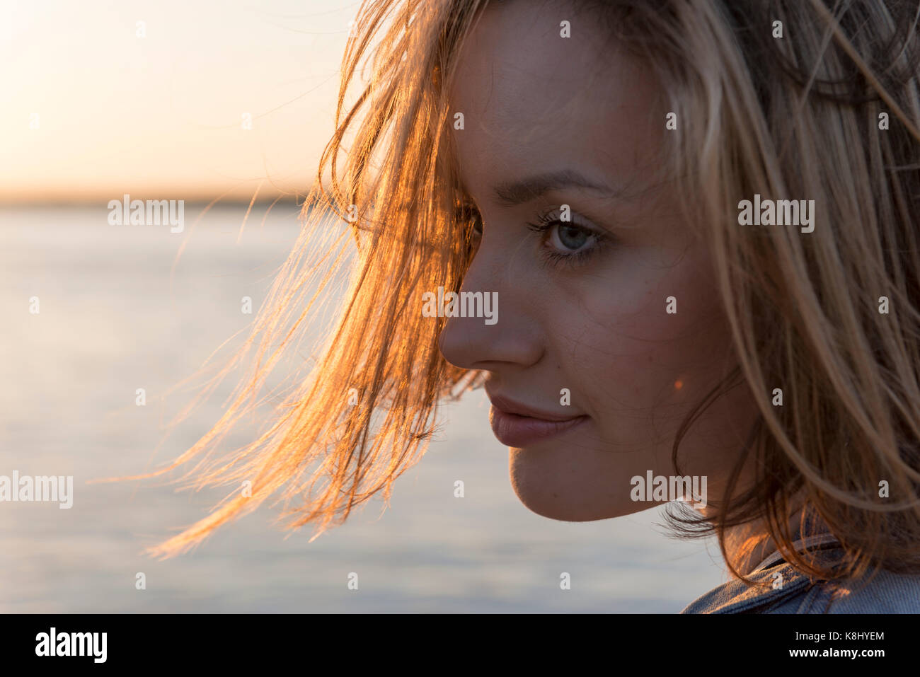 beautiful girl looks away on the river and sunset background Stock ...