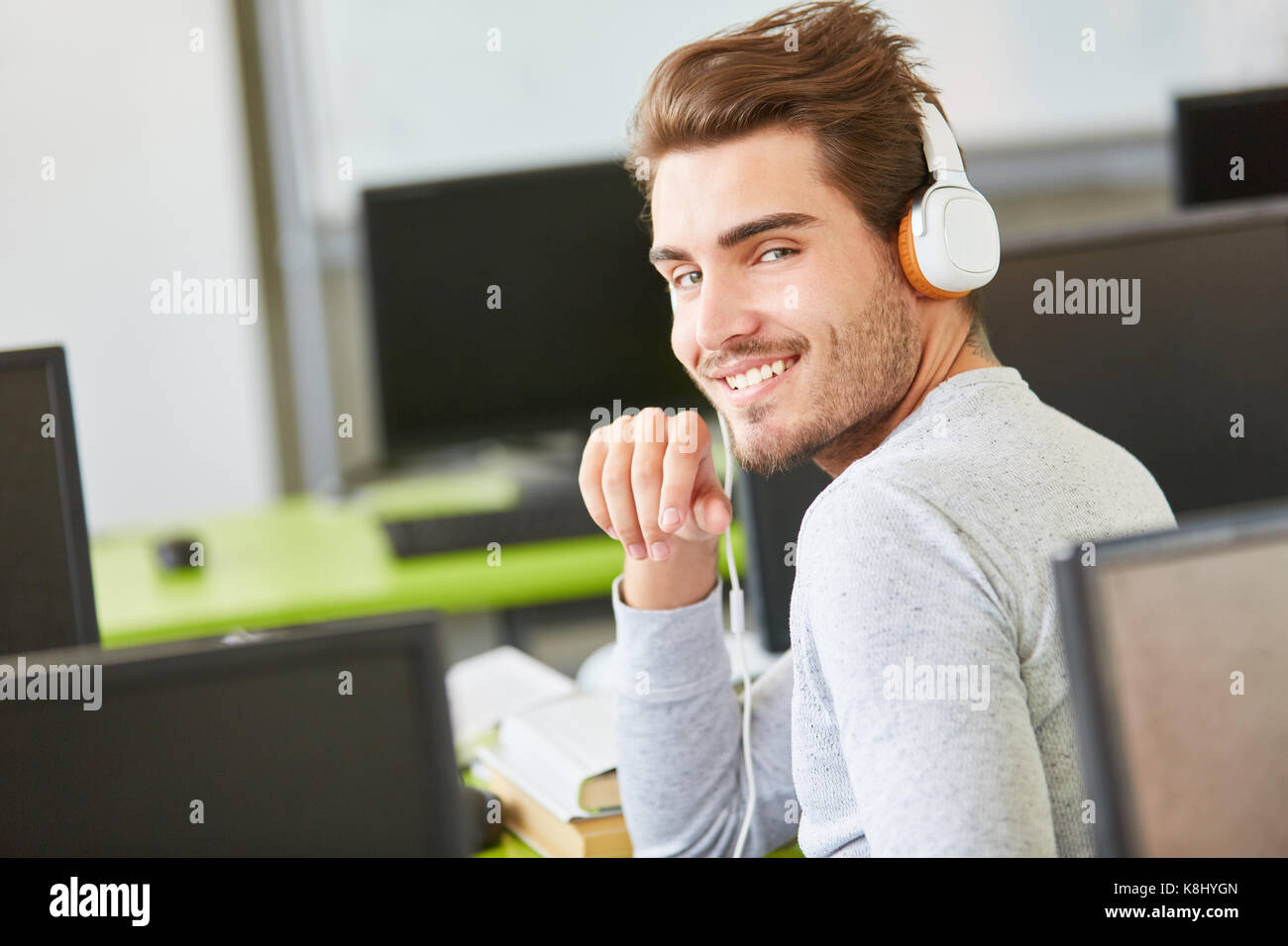 Man as student with headphones in computer science class Stock Photo
