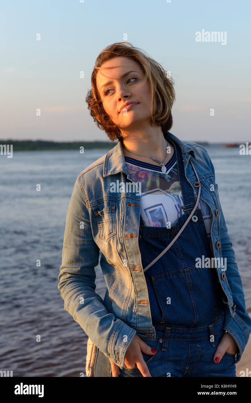 young beautiful girl near the river enjoying sunset Stock Photo - Alamy