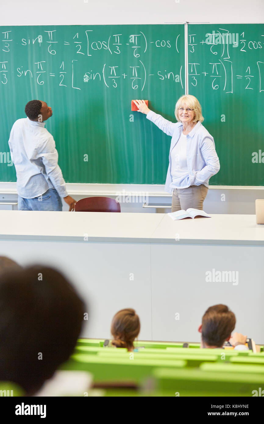Maths lessons in university with students and teacher using blackboard Stock Photo