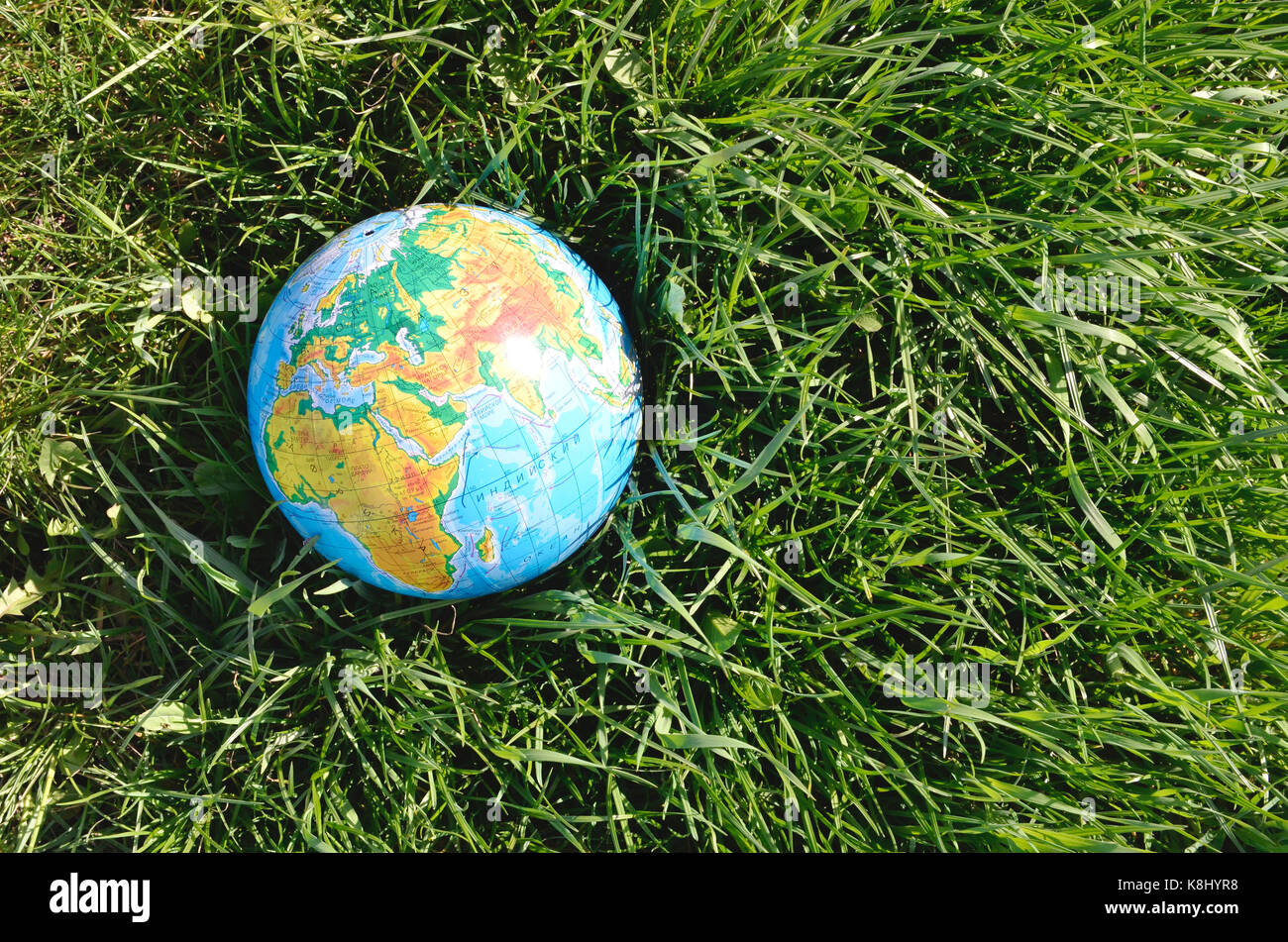 Globe lies on green grass. Concept - Earth Day Stock Photo - Alamy