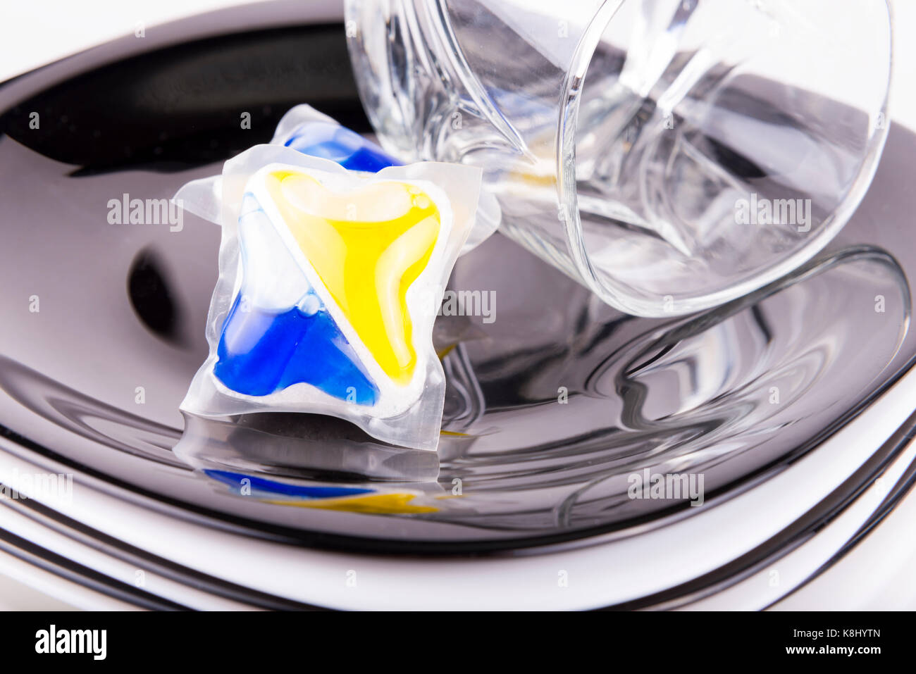 composition of several capsules dishwasher soap with dish Stock Photo