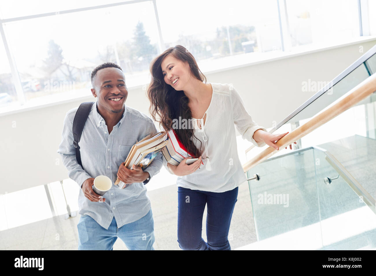Interracial students as a couple flirt happy in school Stock Photo