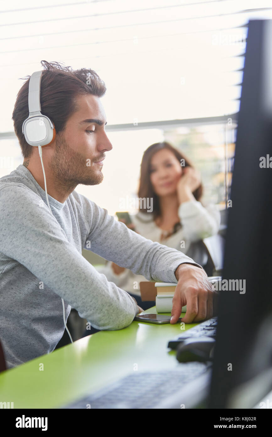 Student in computer e-learning course training wears headphones Stock Photo