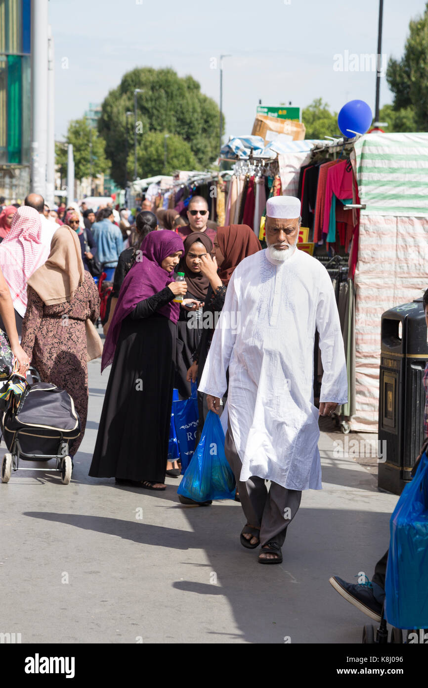 Muslim man wearing a kaftan walking on Whitechapel Road, East London, UK Stock Photo