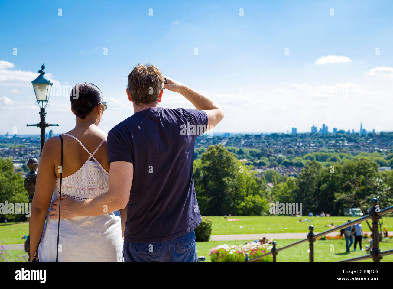 Couple looking at London city skyline from Alexandra Palace Park on a sunny day, London, UK Stock Photo